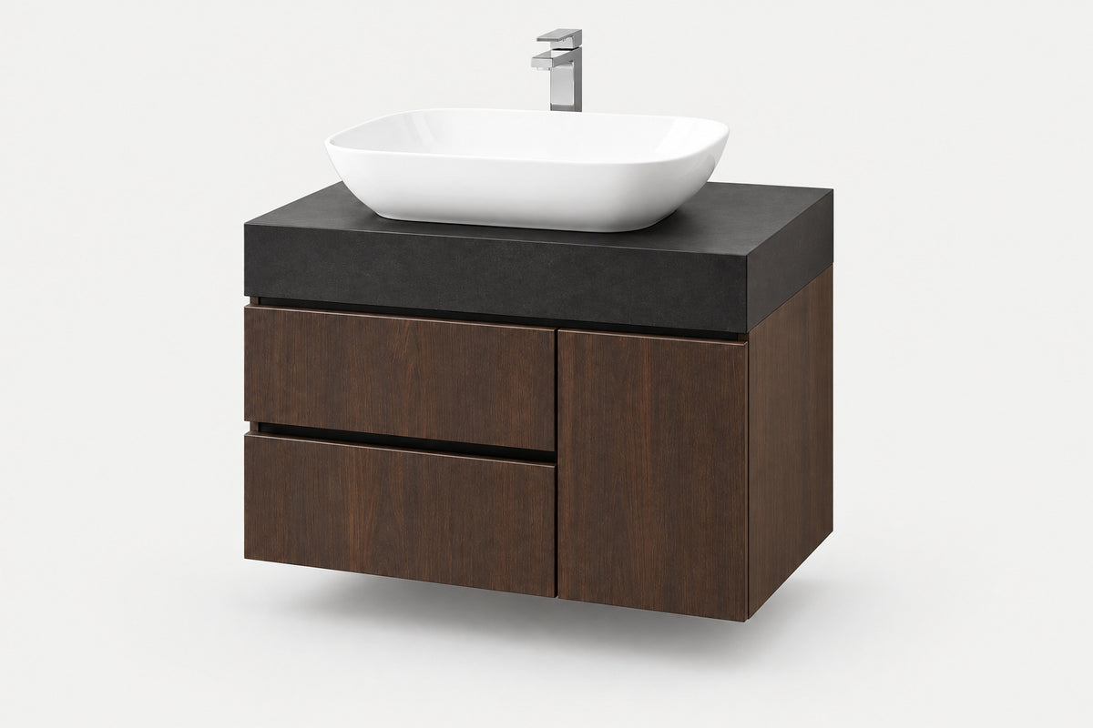 A modern floating bathroom vanity with a dark wood cabinet, a matte black countertop, a white vessel sink, and a chrome faucet, shown on a light gray background.
