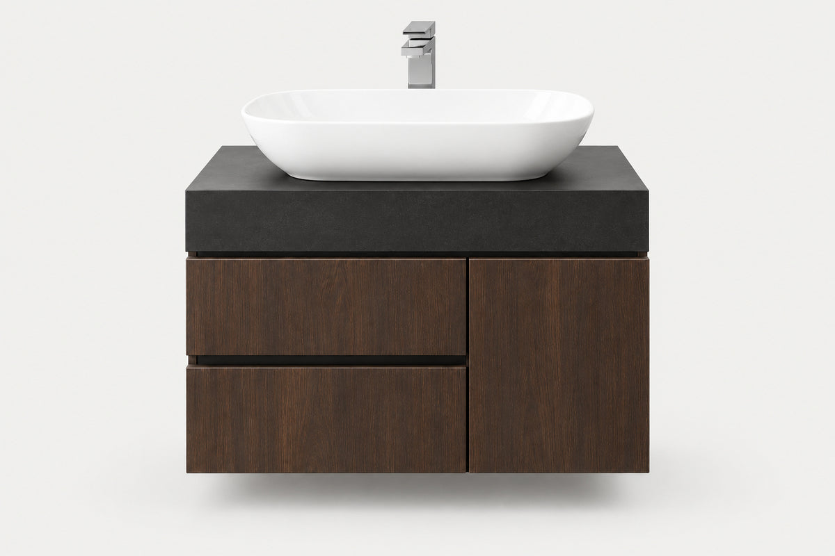 A modern floating bathroom vanity with a dark wood cabinet, a matte black top, and a white oval vessel sink with a chrome faucet, shown against a light gray background.