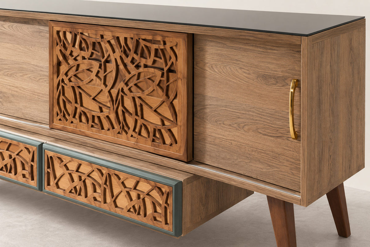 Mid-century modern wooden sideboard with carved geometric panel doors, a black glass top, and gold-toned hardware, shown in a clean studio setting.
