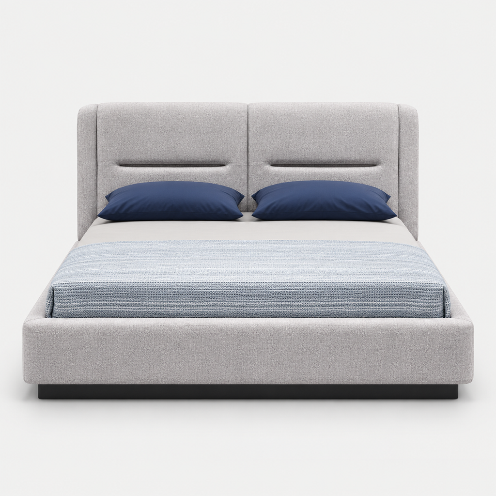 A modern platform bed with a light gray upholstered frame and tall segmented headboard, styled with two navy blue pillows and a textured blue-gray striped duvet, shown against a plain light gray background.