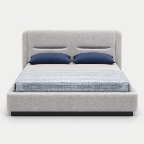 A modern platform bed with a light gray upholstered frame and tall segmented headboard, styled with two navy blue pillows and a textured blue-gray striped duvet, shown against a plain light gray background.
