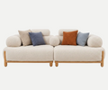 A modern two-seater sofa with rounded boucle upholstery in a warm off-white color, supported by a light natural wood frame. It is styled with five decorative throw pillows in beige, slate blue, rust orange, and light blue, set against a seamless white background.