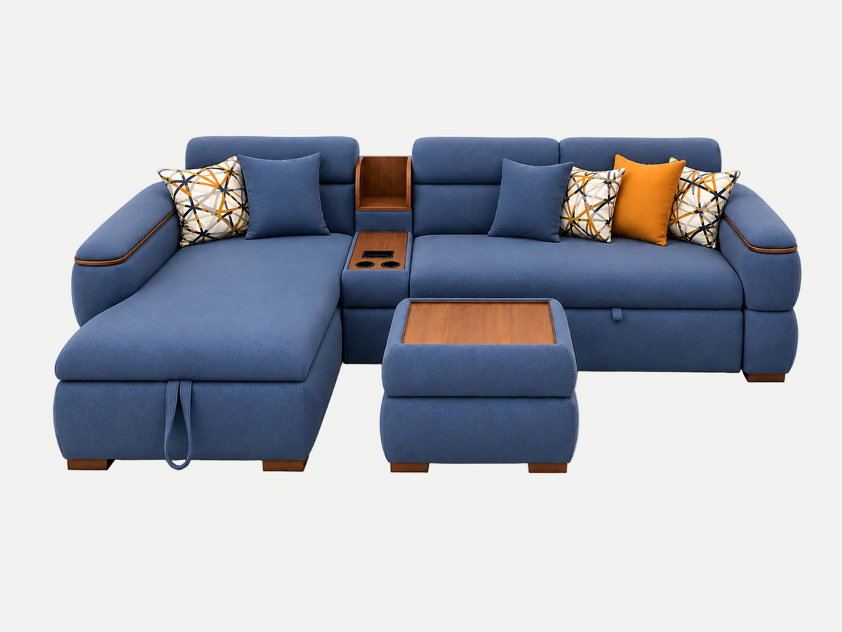 A blue sectional sofa with a chaise lounge, matching ottoman, and decorative throw pillows, shown on a plain white background.