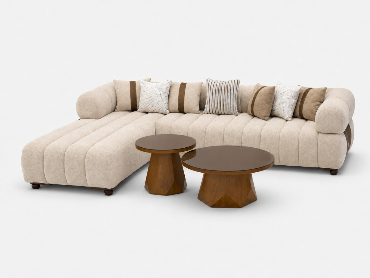 A modern beige sectional sofa with tufted channel detailing, styled with brown and cream accent pillows, accompanied by two matching low wooden coffee tables on a clean white background.