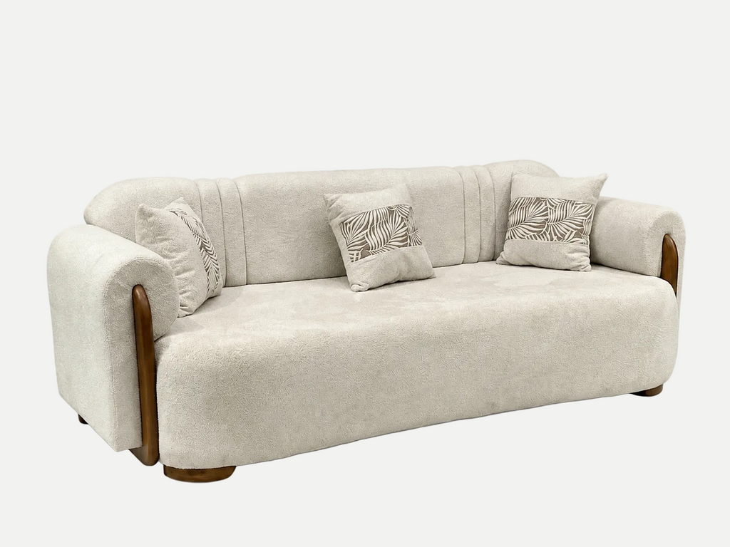 A modern upholstered loveseat sofa in a textured light beige fabric, featuring curved wooden legs and armrests, with three decorative throw pillows on a solid white background.