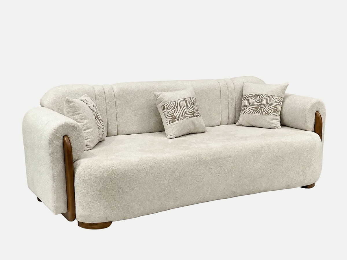 A modern upholstered loveseat sofa in a textured light beige fabric, featuring curved wooden legs and armrests, with three decorative throw pillows on a solid white background.