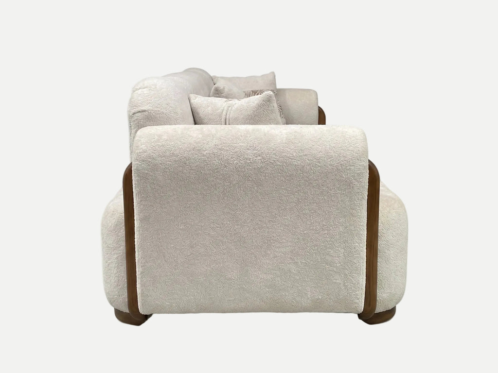 A modern low-profile loveseat sofa upholstered in a textured cream bouclé fabric, featuring contrasting dark brown side panels and legs, shown from a direct front angle on a white background.