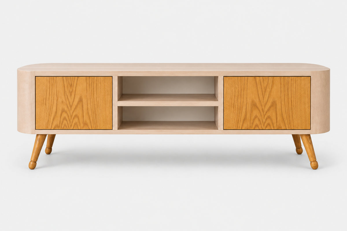 A mid-century modern TV stand or media console with a light beige wood frame, two warm golden-brown wood cabinet doors, open center shelving, and tapered wooden legs, shown against a plain light gray background.